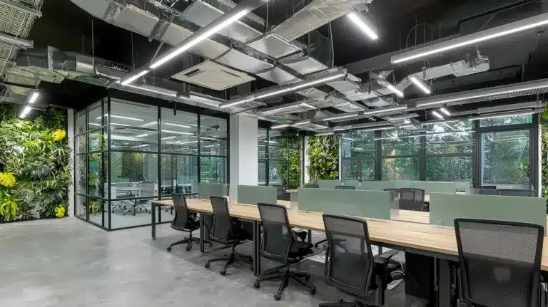 Bureau moderne avec murs végétaux, bureaux en bois et cloisons vitrées