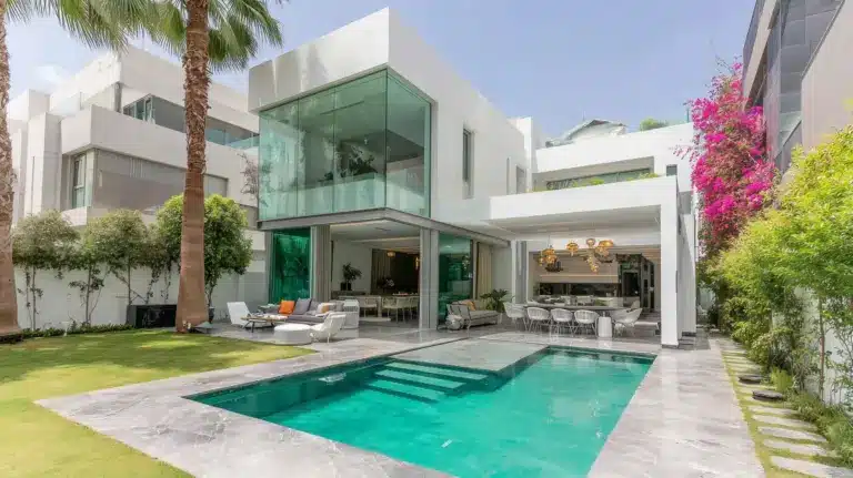 Villa blanche contemporaine à Rabat avec piscine, chaises longues, toit plat, baies noires et bougainvillée