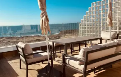 Terrasse d'une villa en front de mer à louer à Harhoura, avec salon, table à manger et vue sur l'Atlantique
