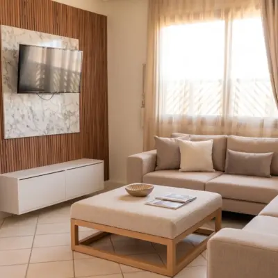 Séjour de suite d'hôtel avec mur en bois, téléviseur et canapé aux tons chauds à Marrakech