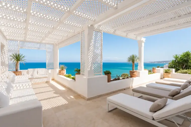 Terrasse à pergola en treillis blanc avec transats, jarres en terre cuite et vue sur la mer turquoise, Marchan, Tanger