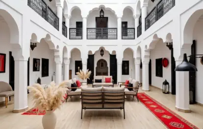 Élégant riad à louer à Tanger, avec arches mauresques, colonnes blanches et espaces de détente traditionnels.