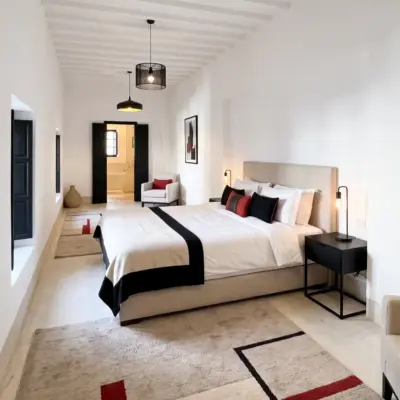 Chambre principale spacieuse avec plafond à poutres et coin salon dans un riad à Tanger